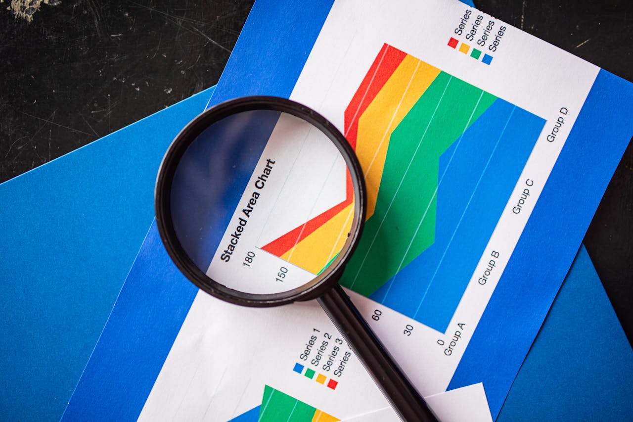 services-02 Magnifying glass highlighting stacked area charts for business analysis.